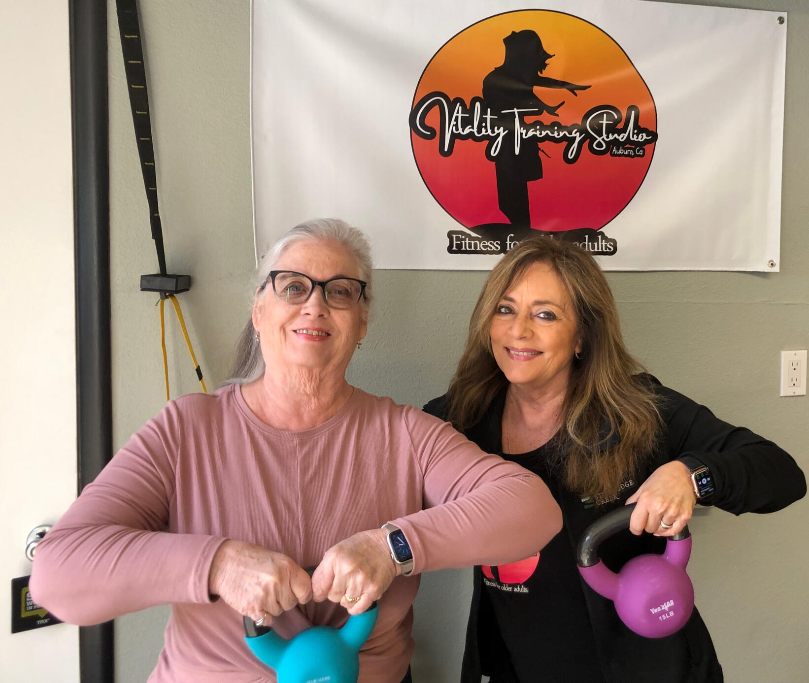 Two women lifting kettlebells